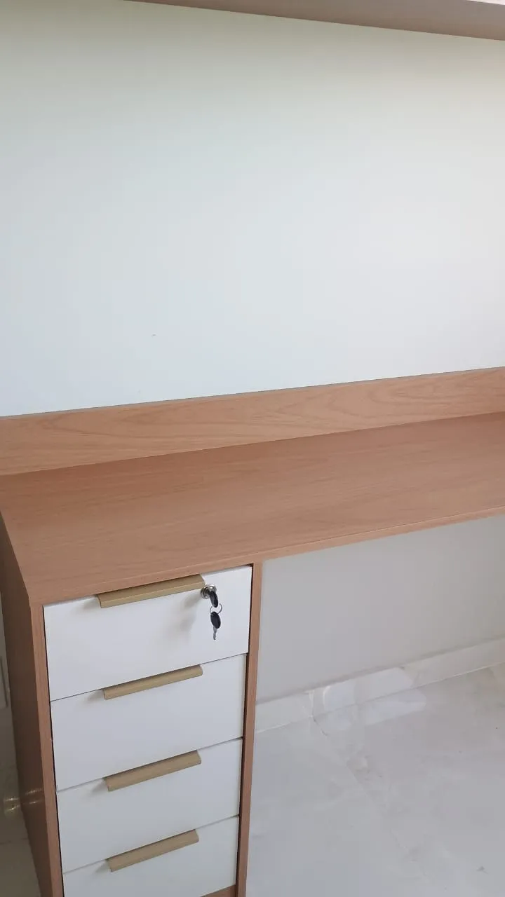 Estante de livros planejada do chão ao teto para escritório de advocacia, com nichos decorativos e iluminação embutida.